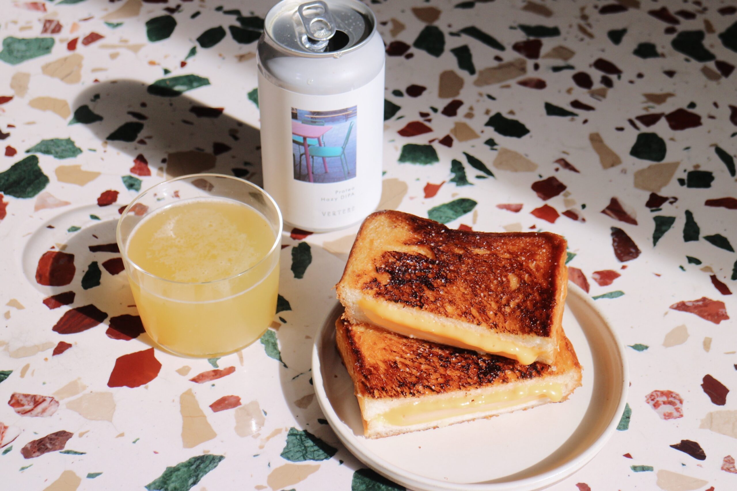 クラフトビールの缶とコップとグリルドチーズサンド