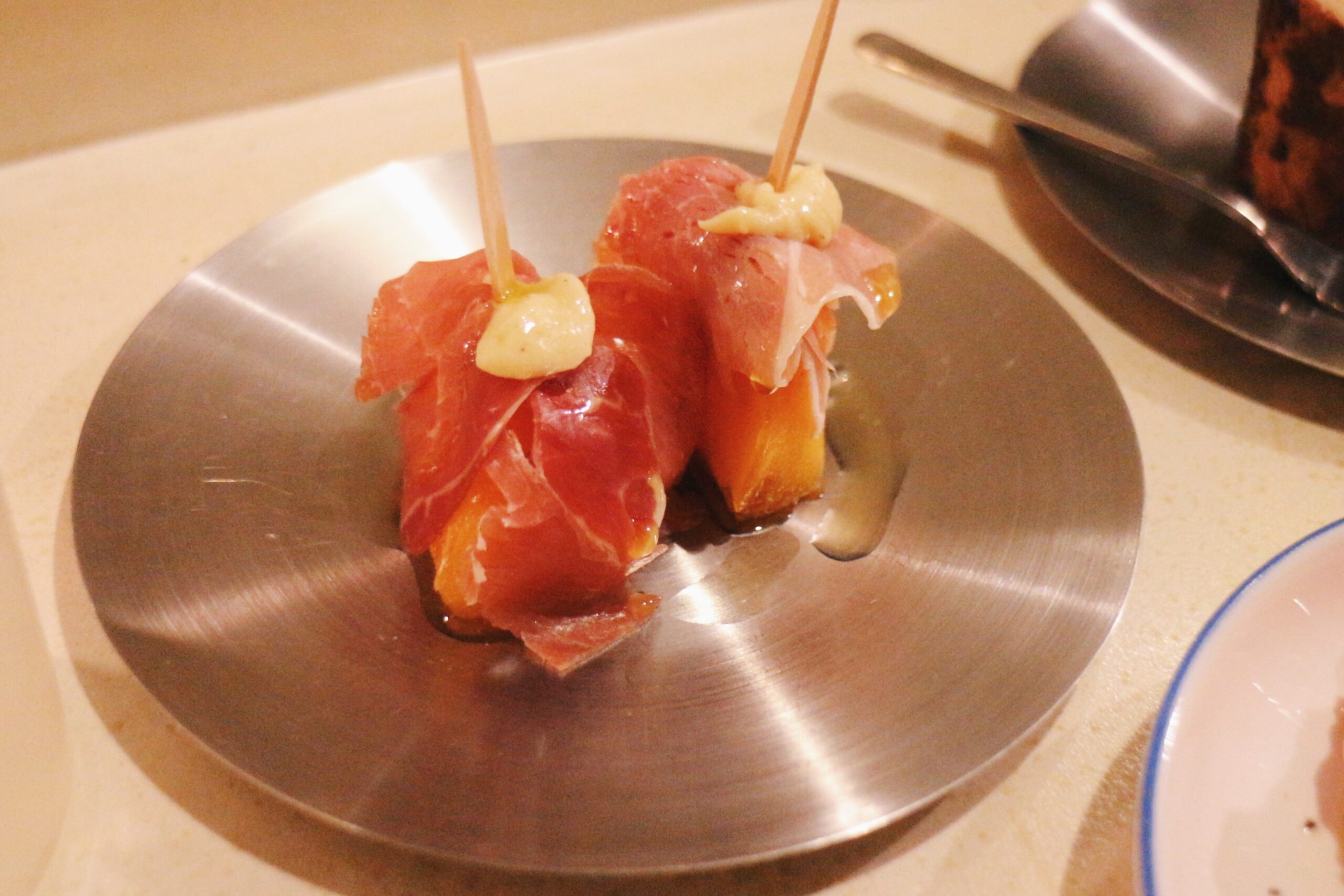 吉祥寺の居酒屋「呑楽Neko」器に2本のった柿とハモンセラーノのピンチョス